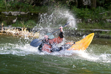 expert white water kayak paddler performing tricks