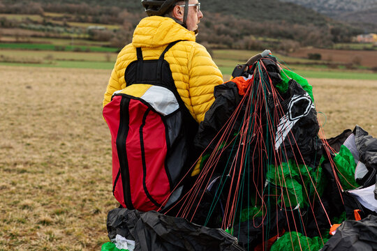 man walking and holding a parachute 