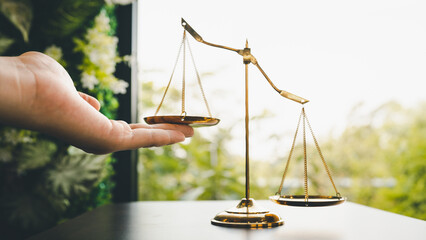 Tip the scales of justice concept as a the hand of a person illegally influencing the legal system for an unfair advantage.	
