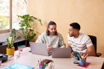Focused colleagues working on netbooks in office