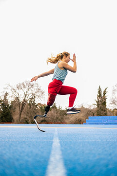 Paralympic athlete woman with bionic leg prosthesis running 