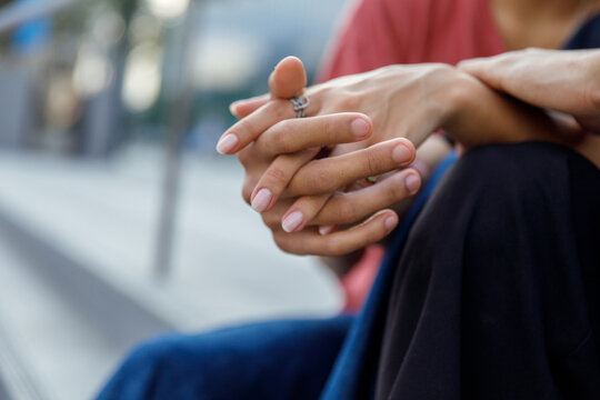 Close up of couple holding hands and relaxing together outside 