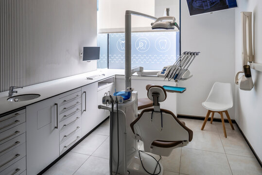 Modern dental practice room with chair, lamp and more equipment