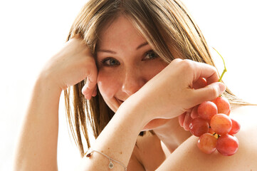 Close-up. Sexy young woman with red grape