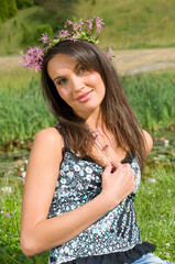 Naklejka na ściany i meble pretty girl outdoor in park in a sunny day with a flowers crown on head
