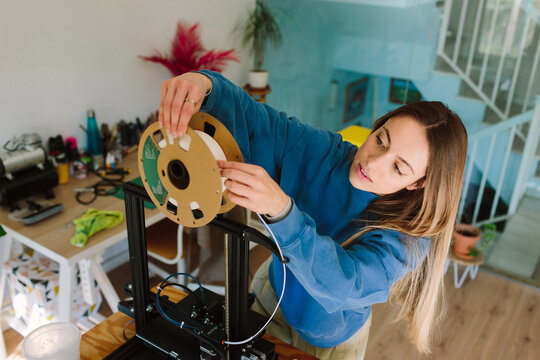 A woman sets up a 3D printer