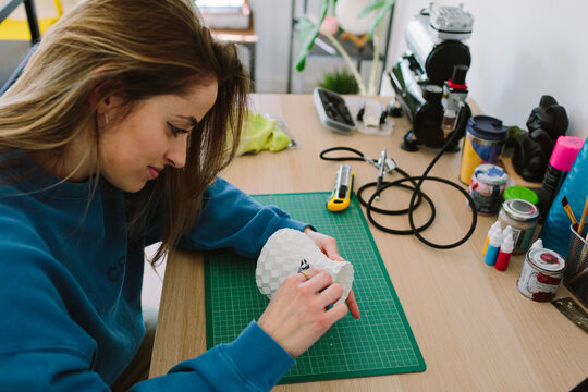 Woman working on a 3D-printed object.