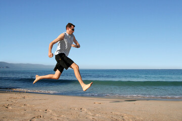 Fototapeta na wymiar Barefooted man running on the beach