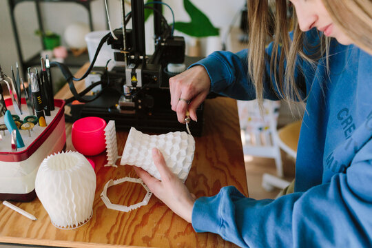 A woman curates a 3D-printed vase 