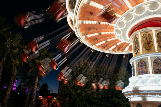 Spinning roundabout in night amusement park.