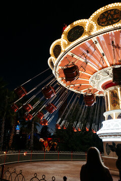 Empty moving roundabout in night amusement park.