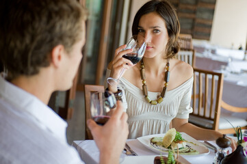 A young couple sitting together in a sophisticaed restaurant