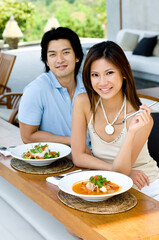 A young Asian couple enjoying lunch oudoors