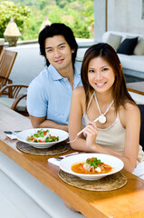 A young Asian couple enjoying lunch oudoors