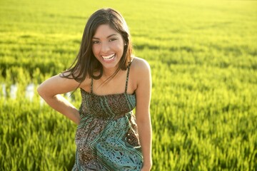 Naklejka na ściany i meble Beautiful brunette indian young woman in the green rice fields meadow