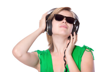 beautiful girl in a green dress and vintage sunglasses listening to music with big headphones, isolated on white