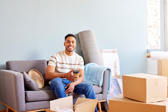 Smiling African American man looking at camera in room full of boxes
