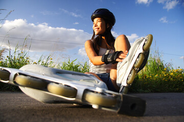 Asian woman on inline rollerblades enjoying a break.