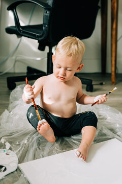 Two Year Old Child Painting His Toes with White Paint