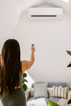 Woman turns on air conditioner in yoga studio