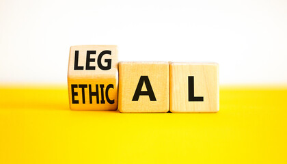 Ethical or legal symbol. Businessman turns wooden cubes and changes the word Ethical to Legal on a...