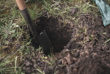 Dig a hole in the ground with a shovel