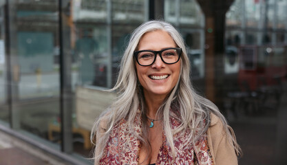 Stylish woman outside wearing jacket and scarf in winter.