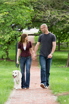 Happy Young Couple Walking the Dog