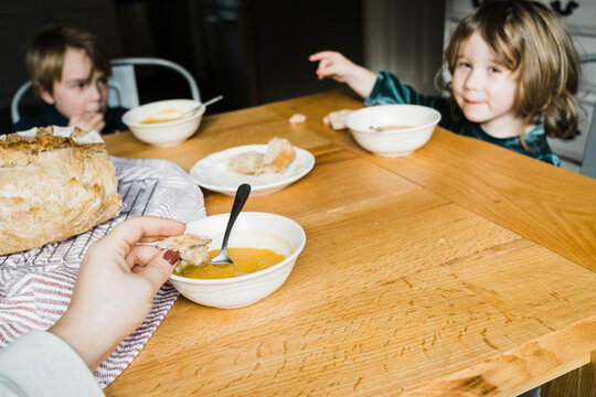 ugc pov photo of hand dipping bread into healthy soup