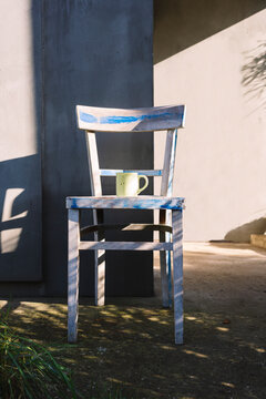 White wooden chair and a tea cup outdoors