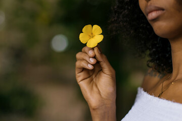 A woman holding a yellow flower 