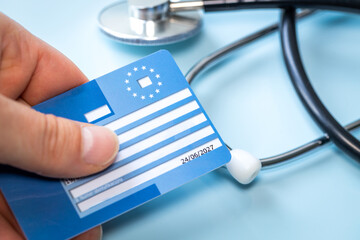 European health insurance card next to a medical stethoscope. Concept, EU document confirming the...
