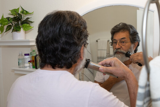 Retired latin man shaving in his bathroom