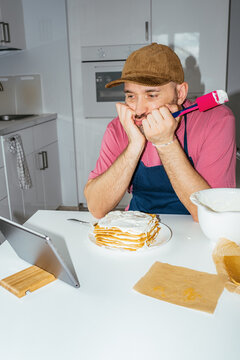 A man is puzzled by cooking a cake according to a recipe from the web