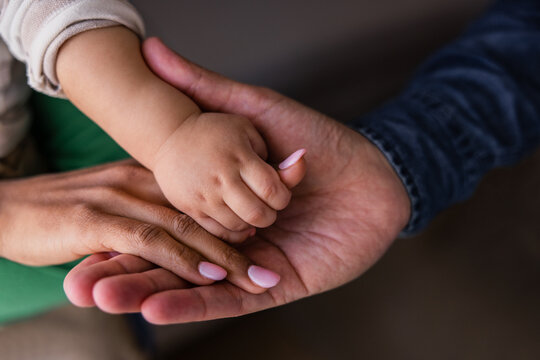 Mother, father and baby joining hands
