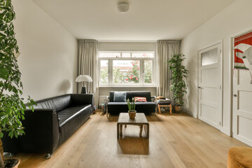 a living room with two couches, a coffee table and a plant on the floor in front of the window