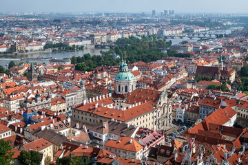 Naklejka premium Aerial panoramic view of Prague, with St. Nicholas Church to be recognised against a cloudy sky.