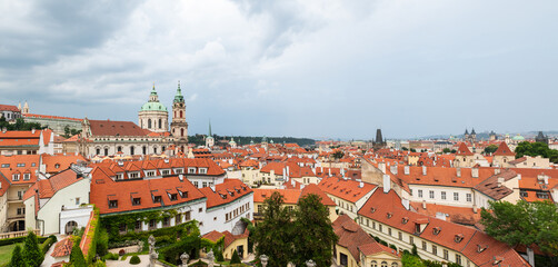 Fototapeta na wymiar Aerial panoramic view of Prague, with St. Nicholas Church to be recognised against a cloudy sky.