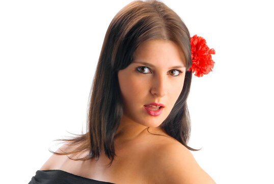 young spanish and cute girl with a black dress and a red carnation betweeen her hair