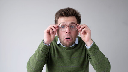 The European young man, in shock, covers his mouth with his hands, thinking, No, this is impossible.