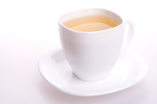 a white cup of tea standing on the table