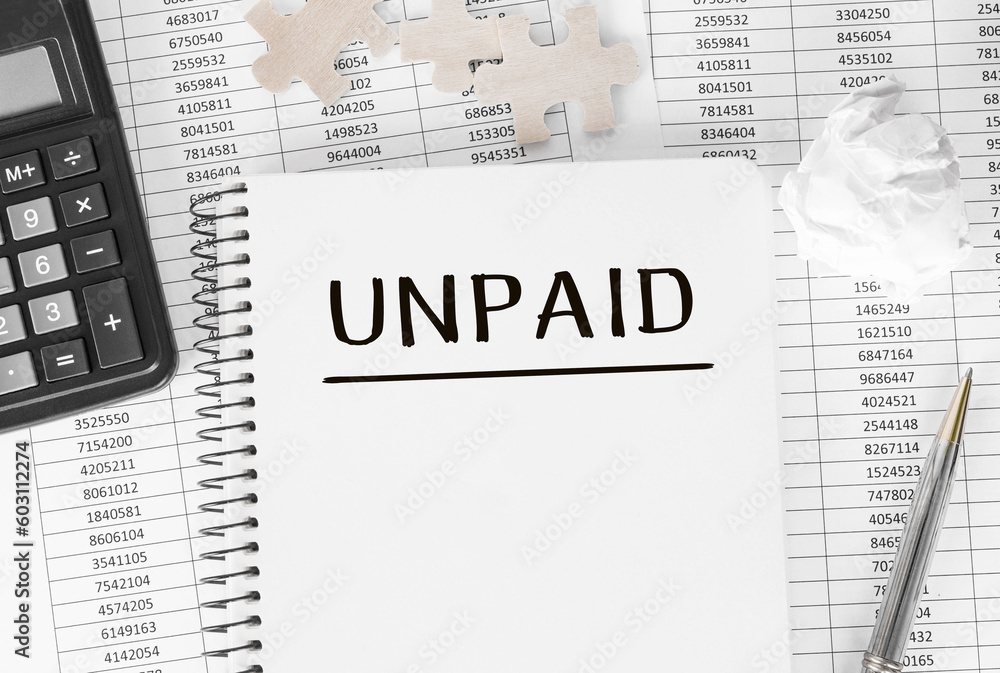 Poster notebook with word unpaid on financial background