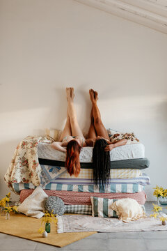 top view of two women lying on a pile of mattresses