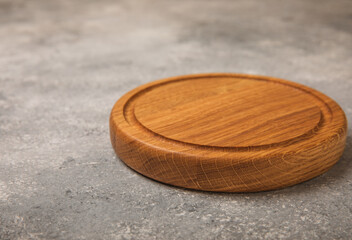 Cutting board on gray kitchen table texture background. Recipe. Kitchenware. Empty modern wooden cutting board. MOCKUP. Place for text. Place to copy.