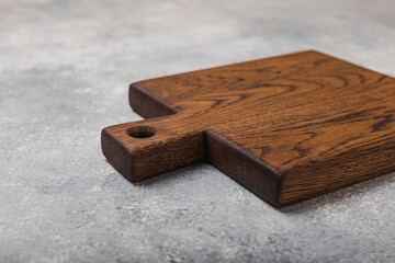 Cutting board on gray kitchen table texture background. Recipe. Kitchenware. Empty modern wooden cutting board. MOCKUP. Place for text. Place to copy.