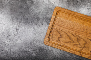 Cutting board on gray kitchen table texture background. Recipe. Kitchenware. Empty modern wooden cutting board. MOCKUP. Place for text. Place to copy.