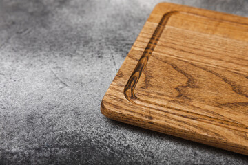 Cutting board on gray kitchen table texture background. Recipe. Kitchenware. Empty modern wooden cutting board. MOCKUP. Place for text. Place to copy.