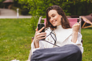 Happy smiling young woman hold smartphone with excited face expression, unable to believe that she...