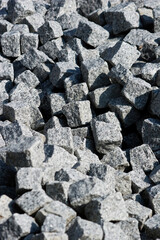 pile of grey cubical shaped granite cobblestones