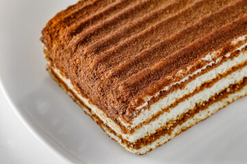 Multi-layered chocolate cake, on white plate, selective focus